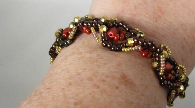 Bracelet avec perles facettées rouges métalliques, brunes et or